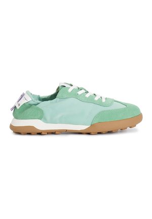 Sneaker verde chiaro con un mix di tessuto liscio e suede, lacci bianchi, suola in gomma texturizzata e un'etichetta viola sul tallone.