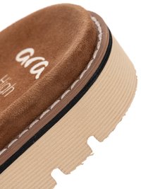 Close-up of brown suede shoe sole with thick beige tread and white stitching along the edge.