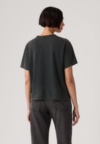 Σκούρο γκρι, κοντομάνικη βαμβακερή μπλούζα με κοντά μανίκια και στρογγυλή λαιμόκοψη, με απαλή υφή και μινιμαλιστικό σχέδιο.