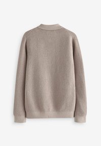 Suéter de punto beige con un acabado texturizado, mangas raglán y cuello y puños de canalé. Silueta simple y relajada sin detalles visibles.