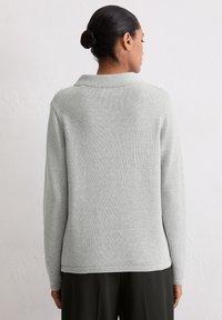 Jasnoszary, teksturowany sweter z dzianiny z kołnierzykiem, długimi rękawami i prostym krojem. Detale szwów wzdłuż ramion i na dole.