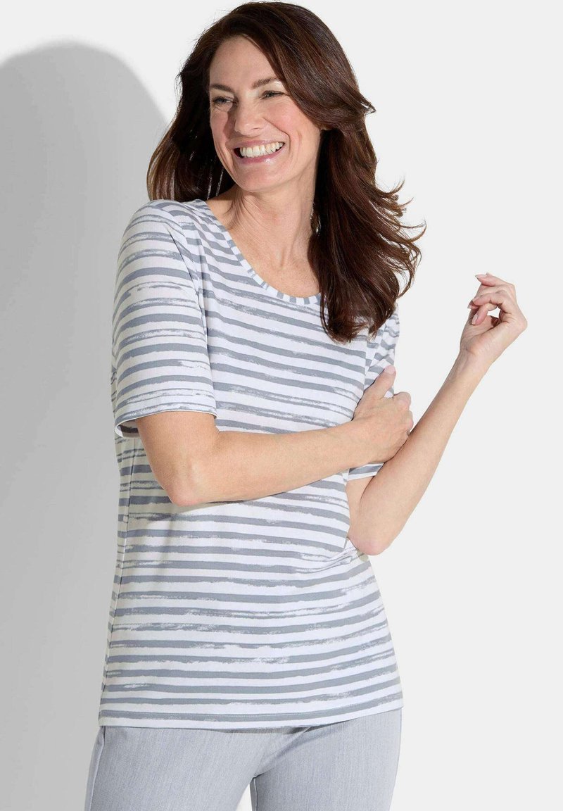 Gestreepte T-shirt in grijs en wit, met een ronde hals en korte mouwen, gedragen door een model met lichtgrijze broek.