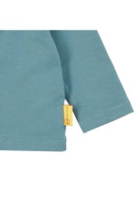 Lichtgroene langemouwen shirt met een geribbelde textuur en een kleurrijke gele label aan de zijkant. Heeft een ronde zoom en gestikte manchetten.