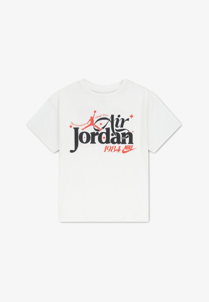 Λευκό βαμβακερό μπλουζάκι με το κείμενο «Air Jordan» σε μαύρο και κόκκινο, με λογότυπο Jumpman και την επιγραφή «1984 Nike» από κάτω. Κοντά μανίκια, στρογγυλή λαιμόκοψη.