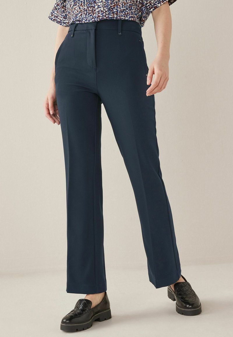 Marineblauwe broek in een gestructureerd ontwerp, met een vlakke voorkant, zijzakken en een rechte pasvorm. Gemaakt met zwarte textuur loafers.