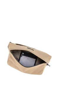 Borsa a vita beige con cerniera parzialmente aperta che rivela una tasca interna in rete con una cerniera nera.
