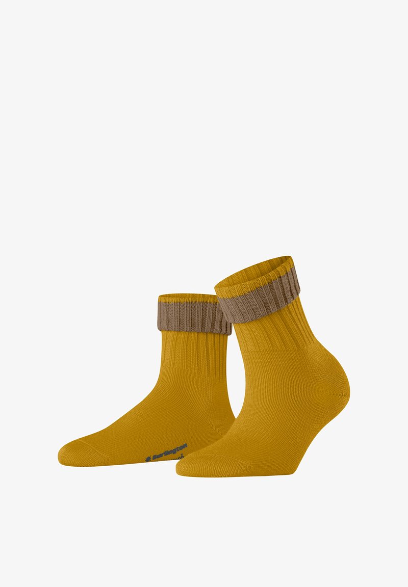 Chaussettes jaunes arrivant à la cheville, avec un revers en brun côtelé, présentant un motif de tricot texturé et un logo subtil sur la semelle.