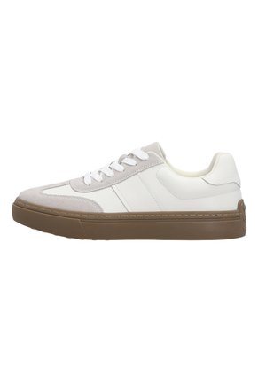 Witte lage sneaker met lichtgrijze suède accenten, witte veters en een dikke bruine rubberen zool, zijkant zicht op een witte achtergrond.