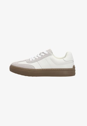 Biały niskoprofilowy sneaker z jasnoszarymi akcentami z zamszu, białymi sznurowadłami i grubą brązową gumową podeszwą, pokazany z boku na białym tle.