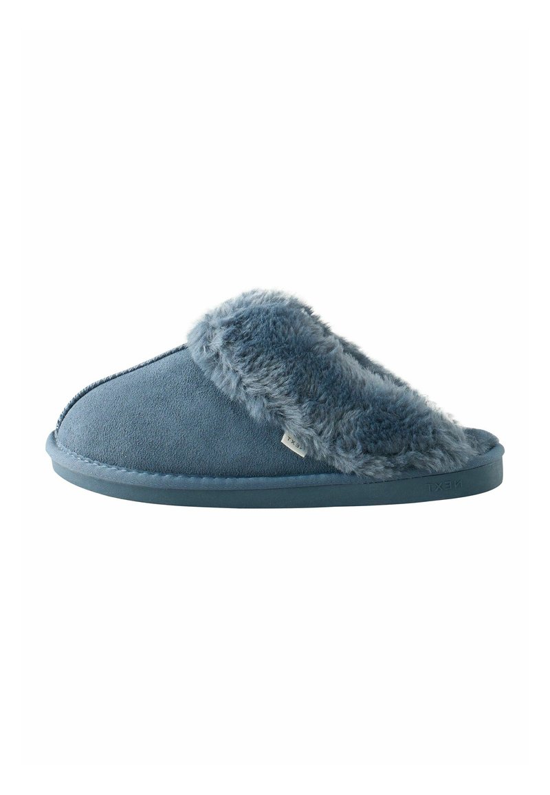 Blå hjemmesko med en blød faux fur-krave, overdel i ruskind, flad gummisål, rund tå og subtil logo-tag nær siden.