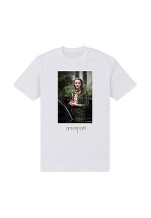 Hvid T-shirt med en kvinde i en grøn tweeddragt, der står ved en bil og holder en rød mappe, med teksten "gossip girl" nedenunder.
