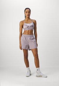 Lila sportieve crop top met een wolkenpatroon, gecombineerd met bijpassende lichte shorts. De outfit heeft een comfortabele pasvorm en een elastische tailleband.