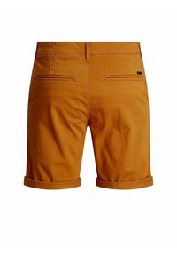 Shorts pour homme couleur rouille avec ourlets retroussés, deux poches passepoilées au dos et passants pour ceinture, vus de dos sur fond blanc.