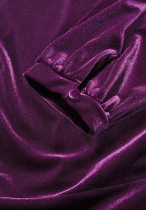 Violet aksominė medžiaga su lygiu, blizgiu paviršiumi. Yra surinkta rankovė su knopkų detalėmis. Bendras minkštas ir prabangus išvaizda.