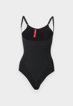 Musta muotoileva yhden kappaleen body säädettävillä olkaimilla ja takakauluksen sisäpuolella punainen "SPANX"-merkitty etiketti.