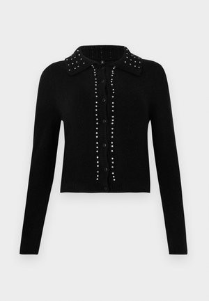 Black cropped cardigan made of soft fabric, featuring a collared neck, button front, and adorned with silver studs along the center and shoulders.