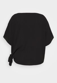 Blusa negra de manga corta con un corte holgado, que presenta un detalle atado en el lado izquierdo, hecha de una tela suave y ligera.