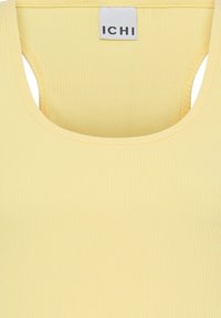 Haut sans manches jaune côtelé avec encolure dégagée et étiquette blanche portant la mention « ICHI » à l'intérieur du col arrière.
