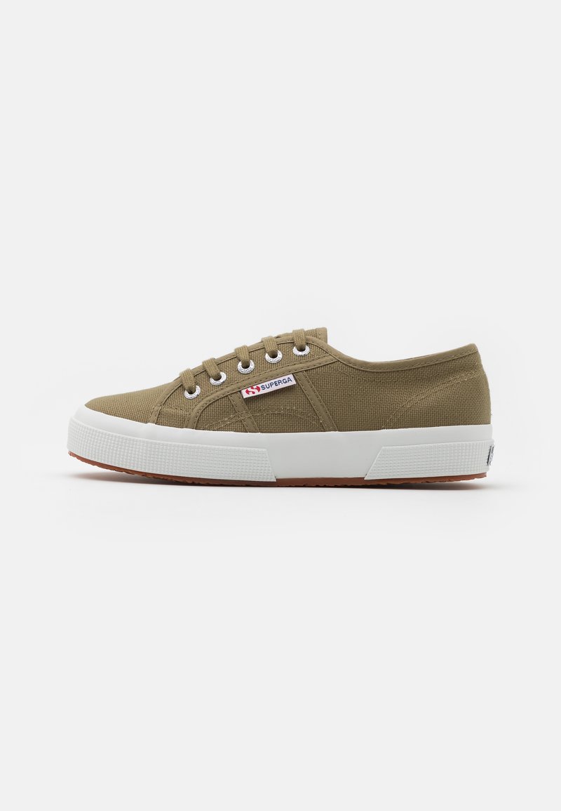 Sneakers in tela verde oliva con suole in gomma bianca, dotati di cinque asole e di un'etichetta con il marchio sul lato per l'identificazione.