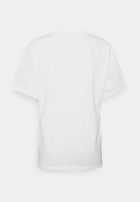 Bílé bavlněné tričko s kulatým výstřihem a krátkými rukávy, s jednoduchým designem a volným střihem. Žádné vzory ani akcenty nejsou viditelné.