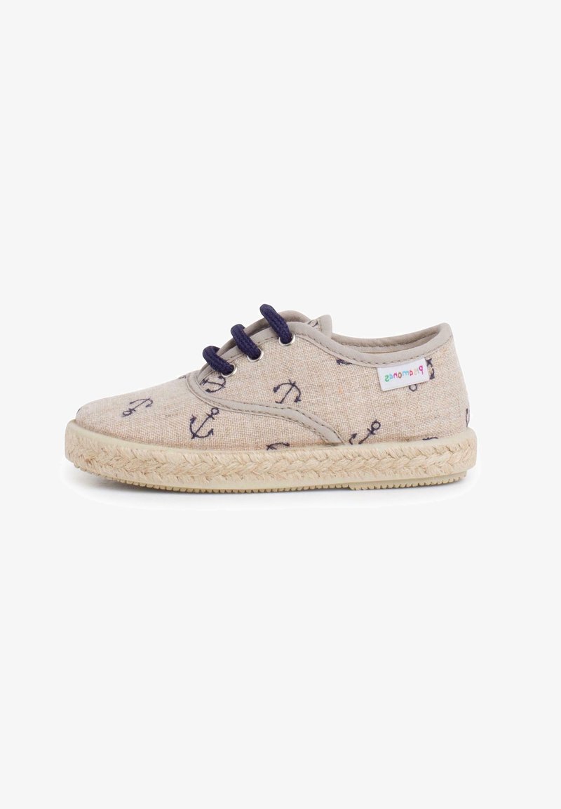 Chaussure enfant en toile beige avec ancres bleu marine imprimées, lacets bleu marine, semelle tissée et petite étiquette de marque colorée sur le côté.