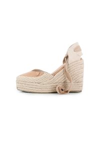 Cuña de espadrille beige con suela de yute trenzado, tira de tela en el tobillo y punta redondeada. Parte superior de ante suave con detalle estampado cerca del talón.