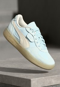 Tenisi bleu deschis din nubuc și piele, cu un accent crem, talpă texturată și șireturi împletite. Logo-ul Puma pe lateral.