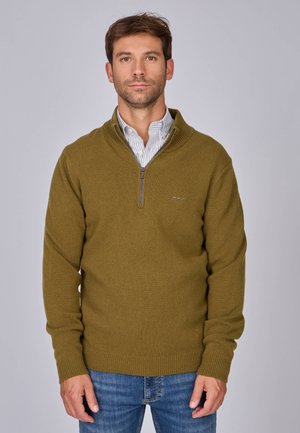 Pull à zip olive en tissu tricoté texturé, avec un col montant, des poignets côtelés et un petit logo sur la poitrine.