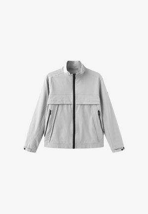 Jasnoszara kurtka na zamek z wysokim kołnierzem, dwoma przednimi kieszeniami na zamki oraz zatrzaskami na mankietach.