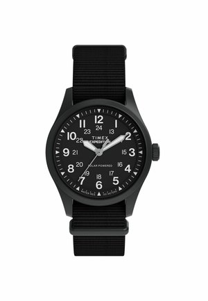 Black Timex Expedition wristwatch with fabric strap, white hour and minute hands, and numeric hour markers including 24-hour format.