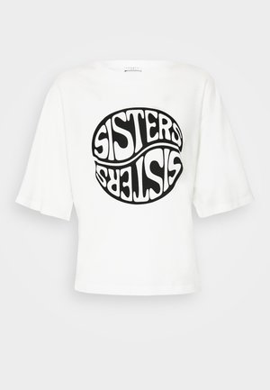 Biała, oversizeowa koszula z krótkim rękawem, na przedzie duży czarny okrągły nadruk z napisem "SISTERS" powtórzonym dwukrotnie, z czego jeden jest do góry nogami.