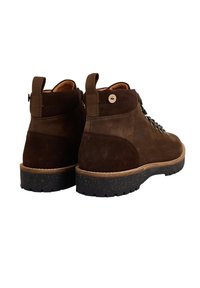 Stivali alla caviglia in suede marrone con una superficie testurizzata, suola in gomma nera e due linguette di presa. Presentano lacci colorati e un dettaglio con logo laterale.