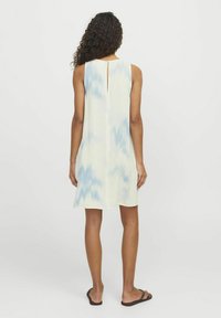 Ärml dresses i gult med blå tie-dye-mönster, med en öppning bak i nacken, tillverkad av lätt material och en avslappnad passform.