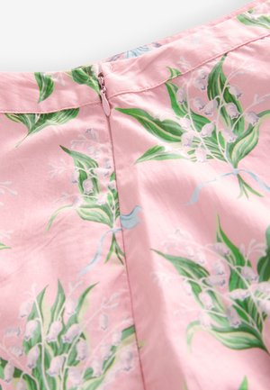 Różowa tkanina z kwiatowym nadrukiem zielonych liści i białych, dzwonkowatych kwiatów, z ukrytym różowym zamkiem błyskawicznym.