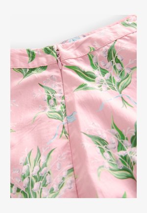 Tessuto rosa con stampa floreale di foglie verdi e fiori bianchi a forma di campana, con chiusura a zip nascosta rosa.