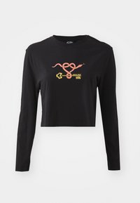 Crop top nero a maniche lunghe realizzato in cotone. Presenta una grafica colorata di un serpente e una chiave sulla parte frontale. Design semplice con colletto recata.
