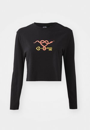 Melnā, garās piedurknes, īsā tops, izgatavots no kokvilnas. Priekšpusē ir krāsains grafikas attēls ar čūsku un atslēgu. Vienkārša apkakles dizains.