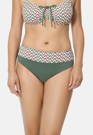 Mujer con bikini verde con cinturilla ancha estampada y parte superior de bikini a juego con nudo delantero.