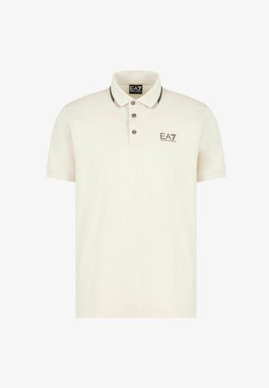 Polo a maniche corte in crema con rifiniture del collo marrone scuro, patta con tre bottoni e logo EA7 sul petto sinistro. Tessuto in morbido misto cotone.