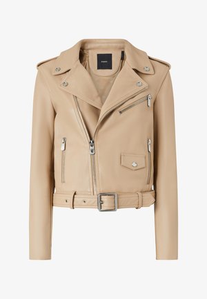 Giacca da motociclista in pelle beige con vita cinturata, zip frontale asimmetrica, tasca sul petto e dettagli in metallo argentato.