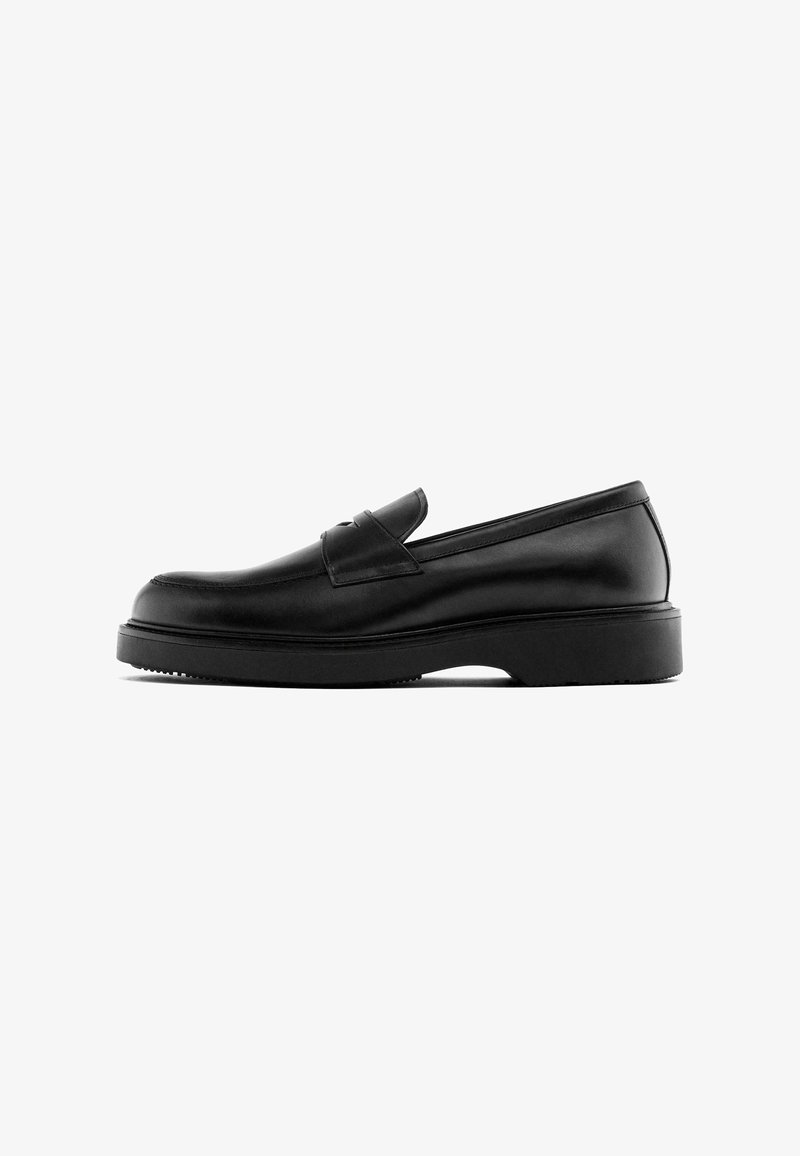 Schwarze Lederloafers mit einem eleganten Design, das eine leicht erhöhte Ferse und subtile Nähtdetails entlang des Vamps und an der Seite aufweist.