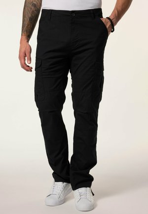 Schwarze Cargo-Hosen mit mehreren Taschen, einem Knopfverschluss und geradem Bein, kombiniert mit weißen Sneakern. Strukturiertes Material.