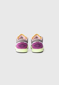 Sneakers met een grijze bovenkant, paarse accenten en een groene zool. Het ontwerp bevat zwarte branding en meerdere kleurelementen op de hiel.