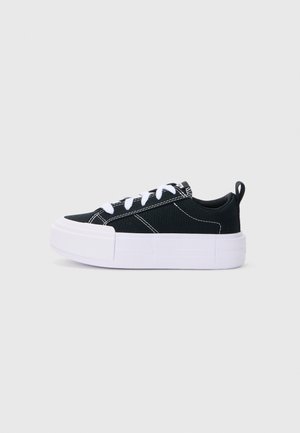 Schwarze Leinenschuhe mit weißen Akzenten und einer dicken weißen Plateausohle. Mit Schnürdesign und einer Schlaufe am Absatz.