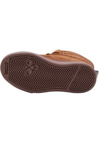 Zapato de ante marrón con acentos de textil trenzado y suela de goma. Presenta un patrón de espiga y un logo en la suela.