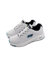 Zapatillas deportivas blancas con una parte superior de malla transpirable y detalles en negro. Cuentan con un cuello acolchado, diseño de cordones y suela de goma azul.