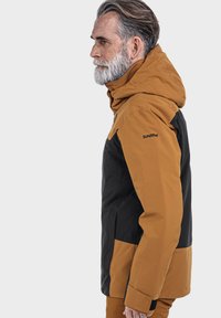 Herrenjacke mit einem braun-schwarzen Farbblockdesign, Kapuze und Logo auf dem Ärmel. Hergestellt aus einem haltbaren, wasserabweisenden Material.