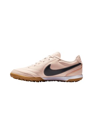 Hellrosa Nike Sneaker mit niedrigem Schnitt, schwarzem Swoosh-Logo, Gummisohle und Schnürverschluss auf weißem Hintergrund.