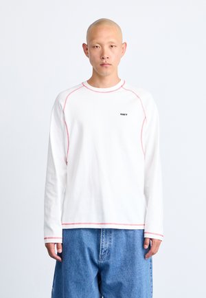 Langärmliges weißes T-Shirt mit roten Kontrastnähten und einem kleinen schwarzen "OBEY"-Logo auf der Brust. Weicher Stoff mit einer bequemen Passform.