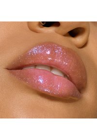Couleur à lèvres rose brillante avec un léger éclat iridescent, montrant une texture lisse et pulpeuse avec un léger éclat. Gros plan sur les lèvres.